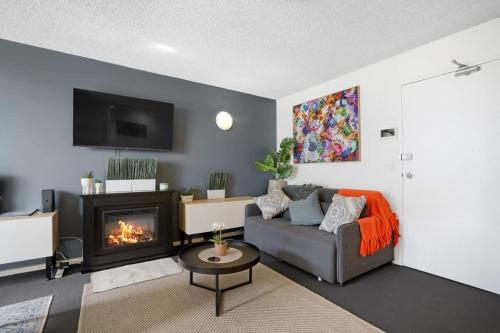 a living room with a couch and a fireplace at Beach-Side Studio Apt with parking spot in Melbourne