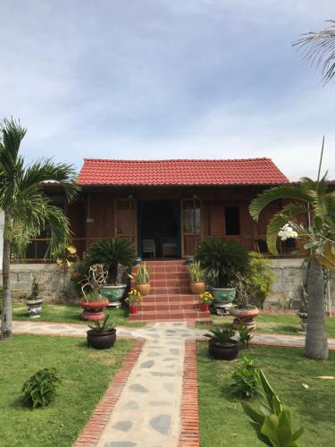 a house with palm trees in front of it at My Anh Garden in Ấp Thiẹn Ái