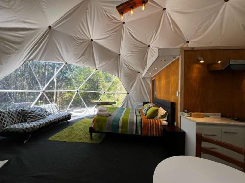 a room with a tent with a bed in it at Domo Panigal in Hornopiren
