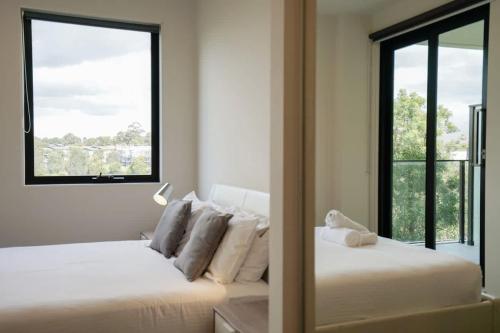 a bedroom with two beds and a large window at Cozy & Convenient Bundoora Apt withparking in Bundoora