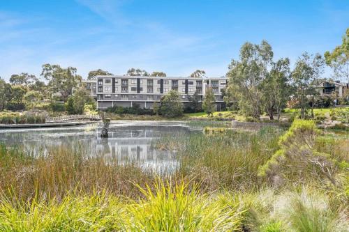 a large building in the middle of a pond at Cozy & Convenient Bundoora Apt withparking in Bundoora