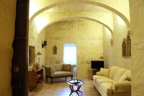 a living room with two couches and a tv at Traditional House of Character in Gharb Gozo in Għarb