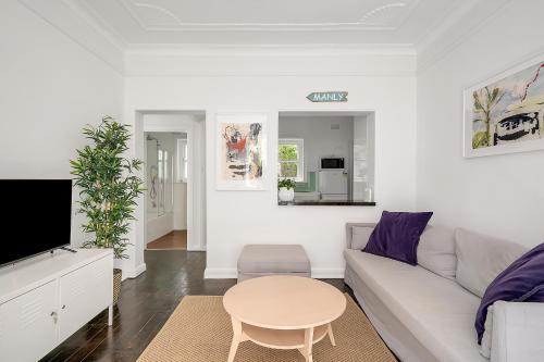 a white living room with a white couch and a table at Level Access, 2 Mins Walk to Corso, Wharf, Harbour in Sydney