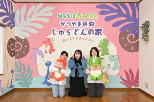 a group of three girls holding dolls in front of a wall at 恐竜好きのファミリーに大人気 かつやま民泊 じゅらどんの家 ぬいぐるみプレゼント中 in Katsuyama