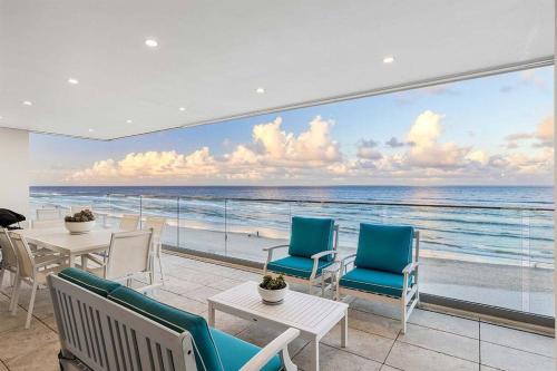 a room with chairs and tables and a view of the ocean at Joy on Jefferson in Gold Coast