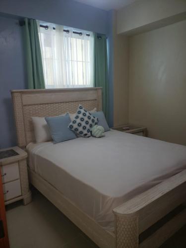 ein Schlafzimmer mit einem großen weißen Bett mit blauen Kissen in der Unterkunft Vamar Apartamentos in San Felipe de Puerto Plata
