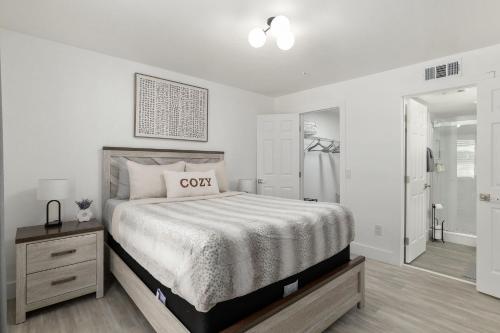 a white bedroom with a bed and a walk in closet at Cozy UF Condo - Near Shands UF VA on Archer Road ! in Gainesville