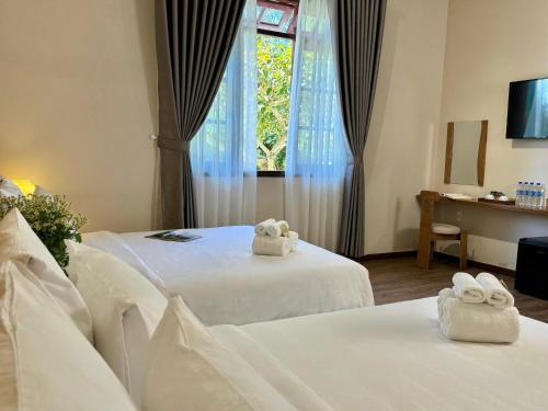 a hotel room with two beds with towels on them at Túi Ba Gang Boutique Hotel in Da Lat