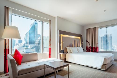 a hotel room with a bed and a couch at Four Points by Sheraton Bangkok Ploenchit Sukhumvit in Bangkok