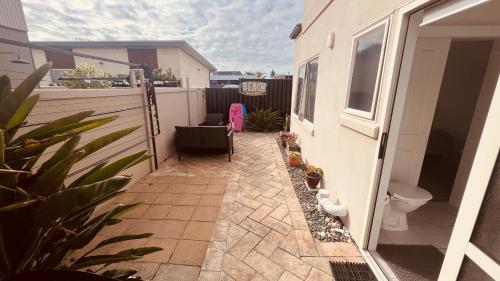 a small patio with a toilet on a balcony at Beachside Bliss in Tauranga