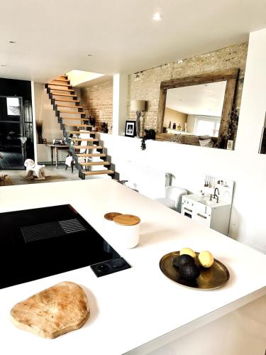 une cuisine avec un comptoir blanc et un escalier dans l'établissement Charming beach house, Les Embruns, à Hermanville-sur-Mer