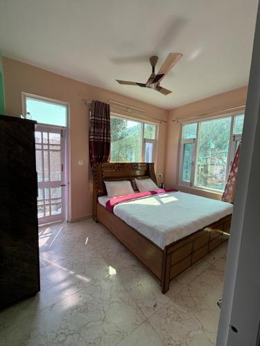 a bedroom with a bed and a ceiling fan at Green Valley View Homestay in Shimla