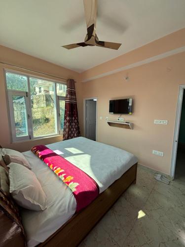 a bedroom with a bed and a ceiling fan at Green Valley View Homestay in Shimla