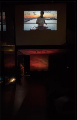 a tv screen in a dark room with a person on it at Casa Vilas Boas Macacos in Nova Lima