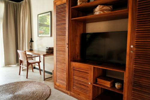 un soggiorno con televisione e tavolo di Wave House Resort Canggu a Canggu