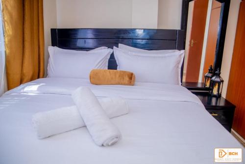 a white bed with two towels on top of it at Bahati homes 2 in Kisii