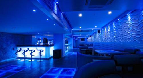 a blue room with couches and a bar at Ramada by Wyndham Chennai Egmore in Chennai