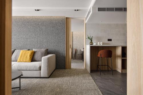 a living room with a couch and a kitchen at JAI Château Hotels & Hostels in Tainan