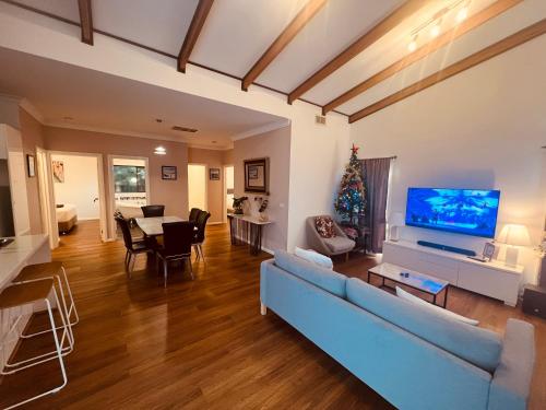 a living room with a blue couch and a tv at Cosy Homes - 15 Minutes Away From Melbourne Airport in St Albans