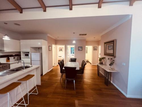 a kitchen and living room with a table and chairs at Cosy Homes - 15 Minutes Away From Melbourne Airport in St Albans