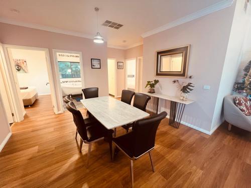 a dining room with a table and chairs at Cosy Homes - 15 Minutes Away From Melbourne Airport in St Albans