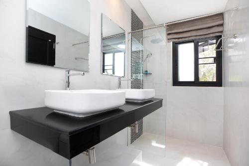 un baño con lavabo y espejo en Namara The Residences B, en Kamala Beach