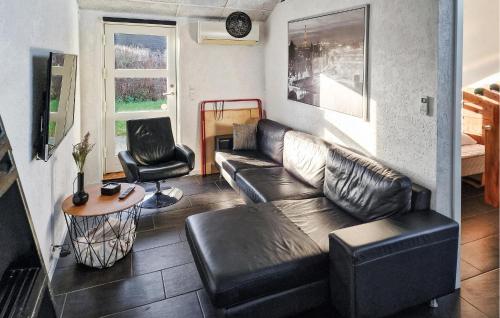 a living room with a leather couch and a table at Beautiful Home In Børkop With Kitchen in Børkop