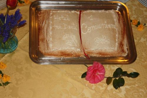 a plastic container of cake on a table with a flower at Hotel Tre Denti in Cantalupa