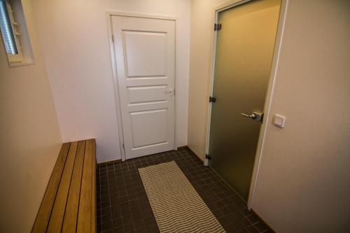 a hallway with a door and a wooden bench at Naapurivaaran Lomakeskus in Vuokatti