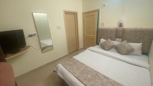a bedroom with a bed with a mirror and a television at Hotel Meadows & Hotel OceanGrass ! Rooftop Cafe ! Music ! Near To Mall Road in Manāli