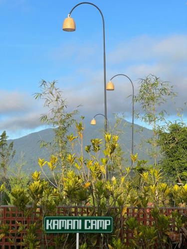 a street light and a street sign with a mountain at KA MANIcamp in Angsri