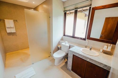 a bathroom with a toilet and a sink at Sri Aksata Ubud Resort in Ubud