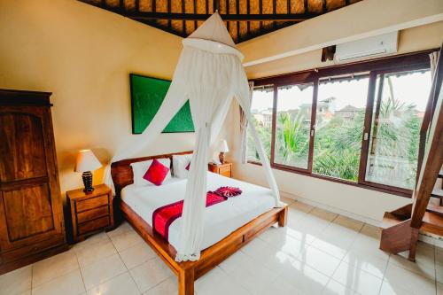 a bedroom with a bed with a canopy at Sri Aksata Ubud Resort in Ubud