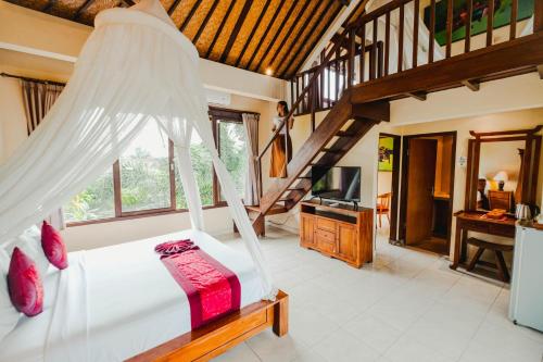 a bedroom with a bed with a mosquito net at Sri Aksata Ubud Resort in Ubud