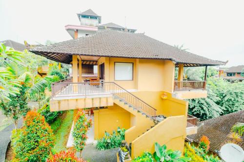 a small yellow house with a balcony at Sri Aksata Ubud Resort in Ubud