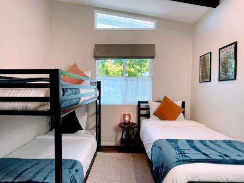 two bunk beds in a room with a window at Redwood Oasis - Private Heated Pool by State Park! in Felton