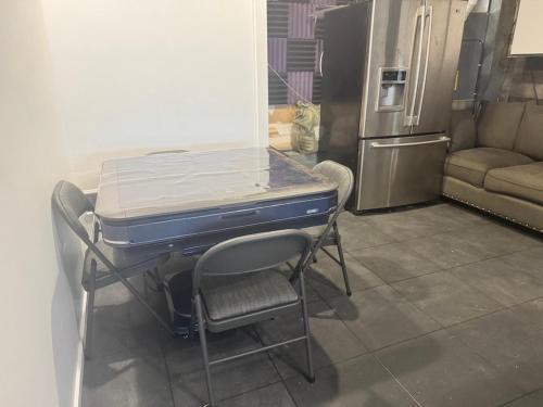 a kitchen with a table and a chair and a refrigerator at Garden Suite Two Bedroom with Hot Tub Sauna Outdoor kitchen and Game Room in Everett