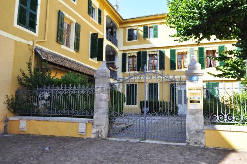 a yellow house with a gate in front of it at Appartements CONFIDENCE hyper centre calme - SEJOURAIXLESBAINS in Aix-les-Bains