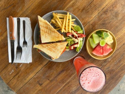 a plate of food with a sandwich and french fries and a drink at KA MANIcamp in Angsri