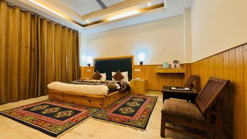 a bedroom with a bed and a chair and a table at HUKAM'S HOLIDAY HOME by HHH in Kasol