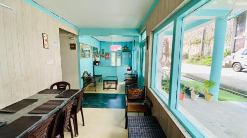 a room with a table and chairs and a window at Hotel Meadows & Hotel OceanGrass ! Rooftop Cafe ! Music ! Near To Mall Road in Manāli