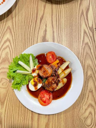 a plate of food with shrimp and vegetables on a table at ndalem singgah malioboro by abiza in Demangan