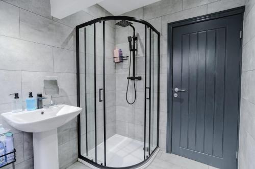 a shower with a glass door and a sink in a bathroom at Stunning Skyview 2BR flat , fast Wifi - Home Away from Home in Central Station