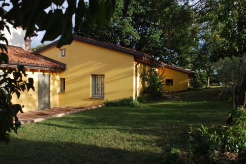 a yellow house with a yard in front of it at Casale13 in Faenza