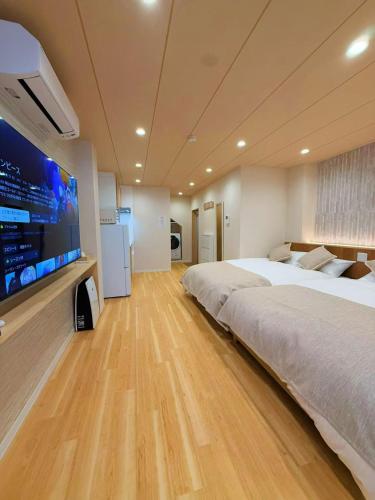 a large bedroom with a large bed and a flat screen tv at M house asakusa kaminarimon tokyo in Tokyo