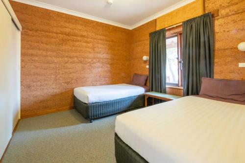 a hotel room with two beds and a window at Mud Hut Motel in Coober Pedy
