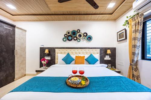a bedroom with a bed with two glasses of wine at SaffronStays Olive Greens, Karjat in Karjat