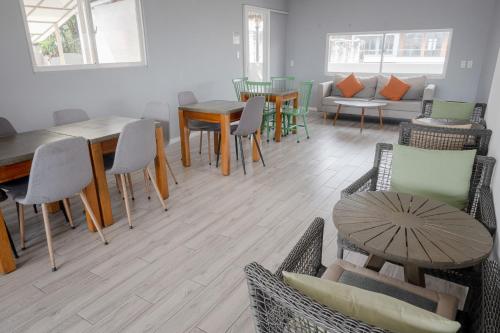 a living room with tables and chairs and a couch at Common Inn Thao Dien in Ho Chi Minh City