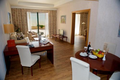 a living room with a table and chairs and a dining room at Ramada Plaza by Wyndham Thraki in Alexandroupoli