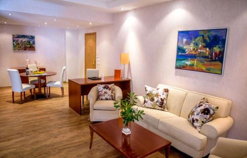 a living room with a couch and a table at Ramada Plaza by Wyndham Thraki in Alexandroupoli